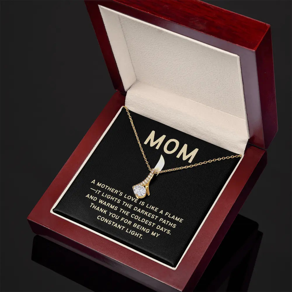Celebrate mom with a gold necklace featuring a cubic zirconia pendant, elegantly displayed in an open mahogany jewelry box. The inside reads MOM and shares a heartfelt message about a mother’s love being a constant light. Find more at the Gifts For Mom store.