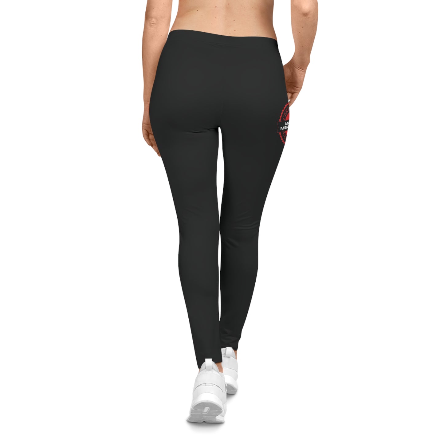 Back view of a person wearing black leggings featuring a red circular logo that reads Mama Mentality. They wear white sneakers against a pristine white background.
