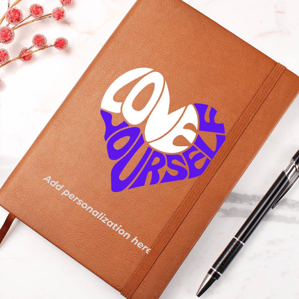 A vegan leather journal featuring an engraved heart made up of the word "love" in white and "yourself" in purple. This journal from the Gifts For Mom store is personalizable.
