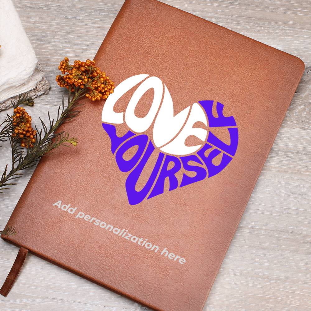 A vegan leather journal featuring an engraved heart made up of the word "love" in white and "yourself" in purple. This journal from the Gifts For Mom store is personalizable.