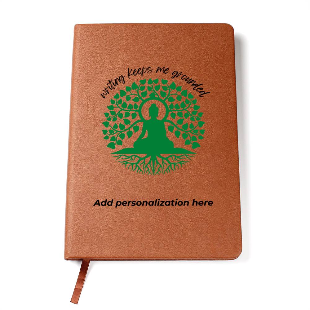 A vegan leather journal featuring an engraved green tree, roots, and a person design beautifully displays the phrase writing keeps me grounded. This journal from the Gifts For Mom store is personalizable.